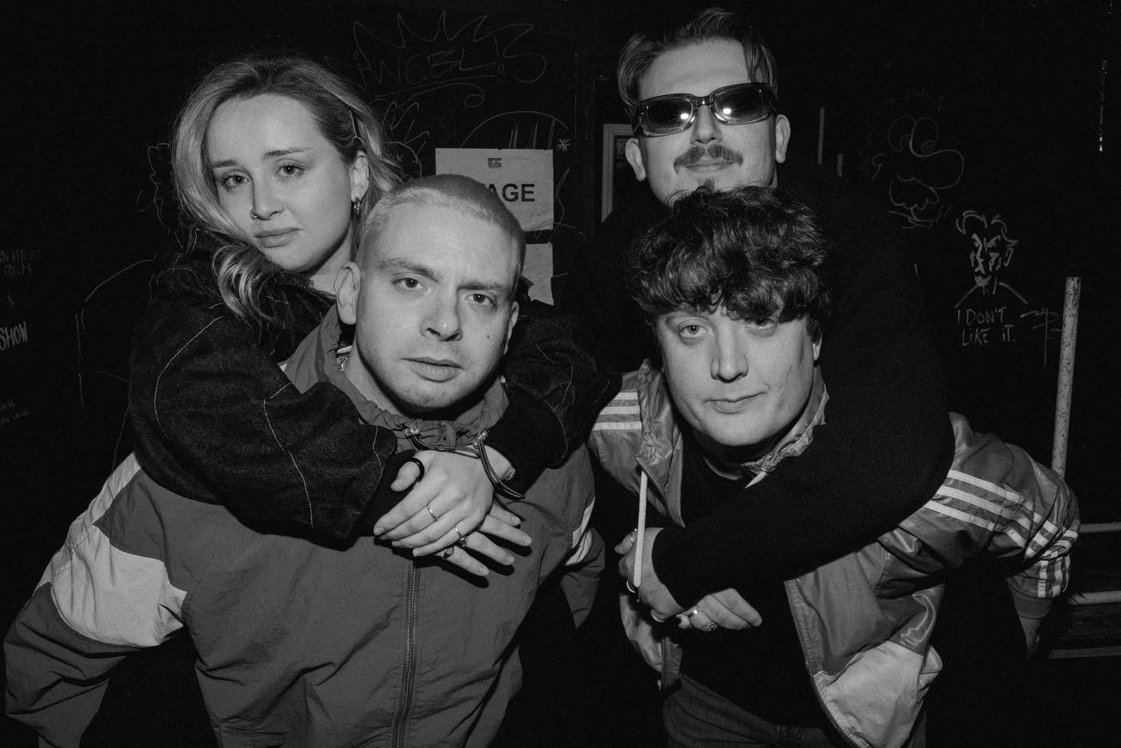 Away Fans — four-piece backstage group shot, piggyback pose