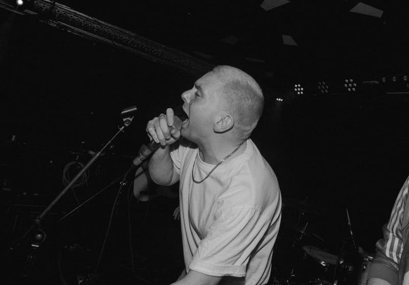 Away Fans live — vocalist at the mic under stage light